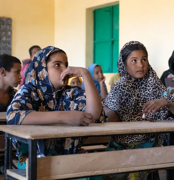 Two young Tuareg girls attentive in a classroom of a school built by Les Puits du Désert